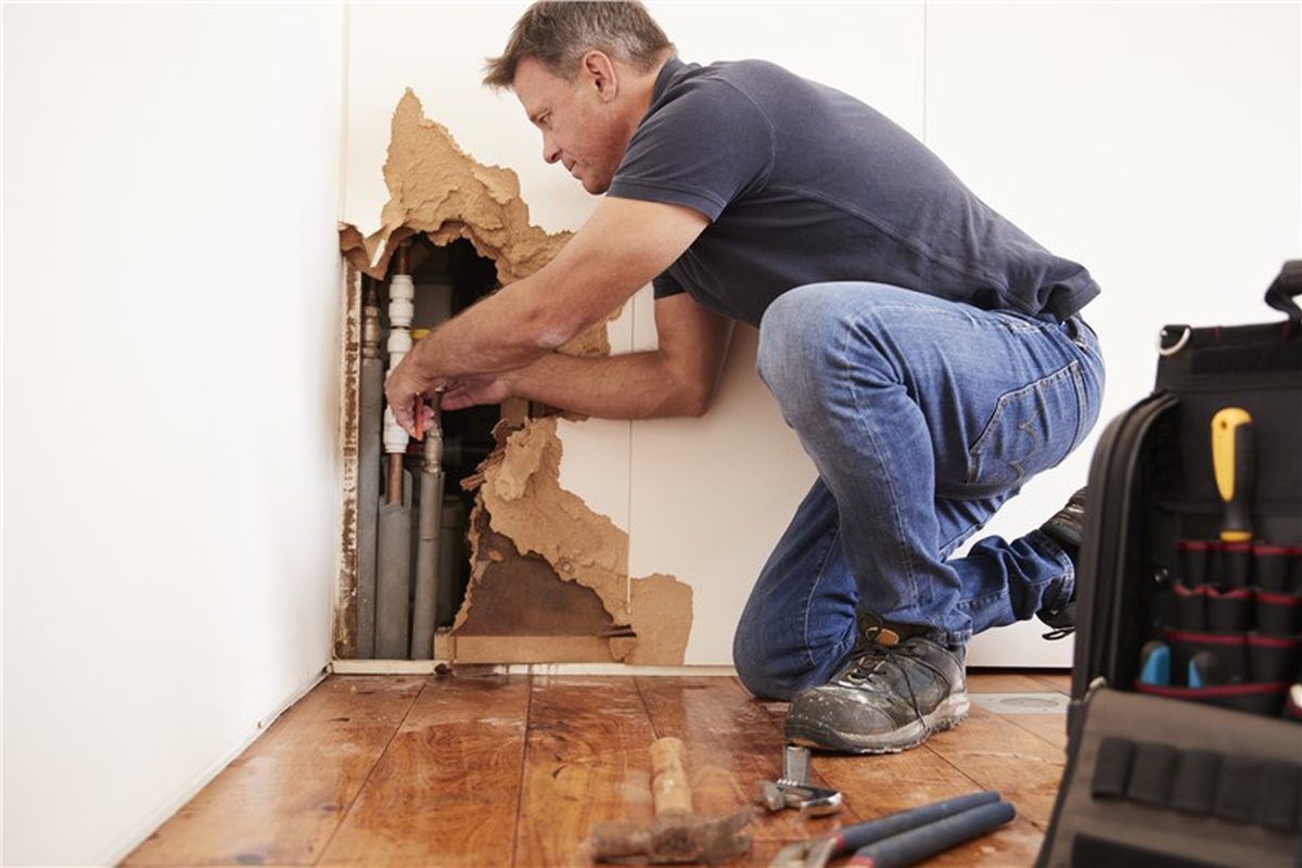 Contractor working on damaged drywall